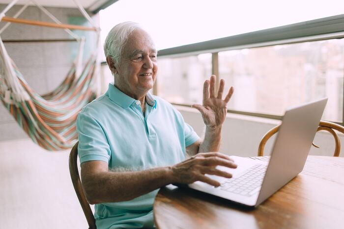 Senhor sorrindo durante uma videochamada no notebook